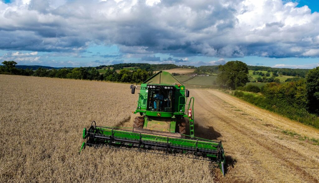 Machinery harvests crop in a large field