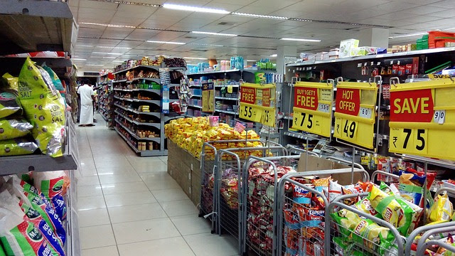 Supermarket aisle with bins full of products on special offer.